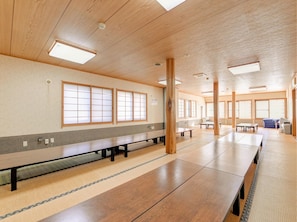 Une pièce spacieuse avec un plancher en bois, un long banc et de grandes fenêtres.