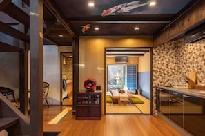 Una cocina moderna con comedor, suelo de madera y vistas a un jardín.