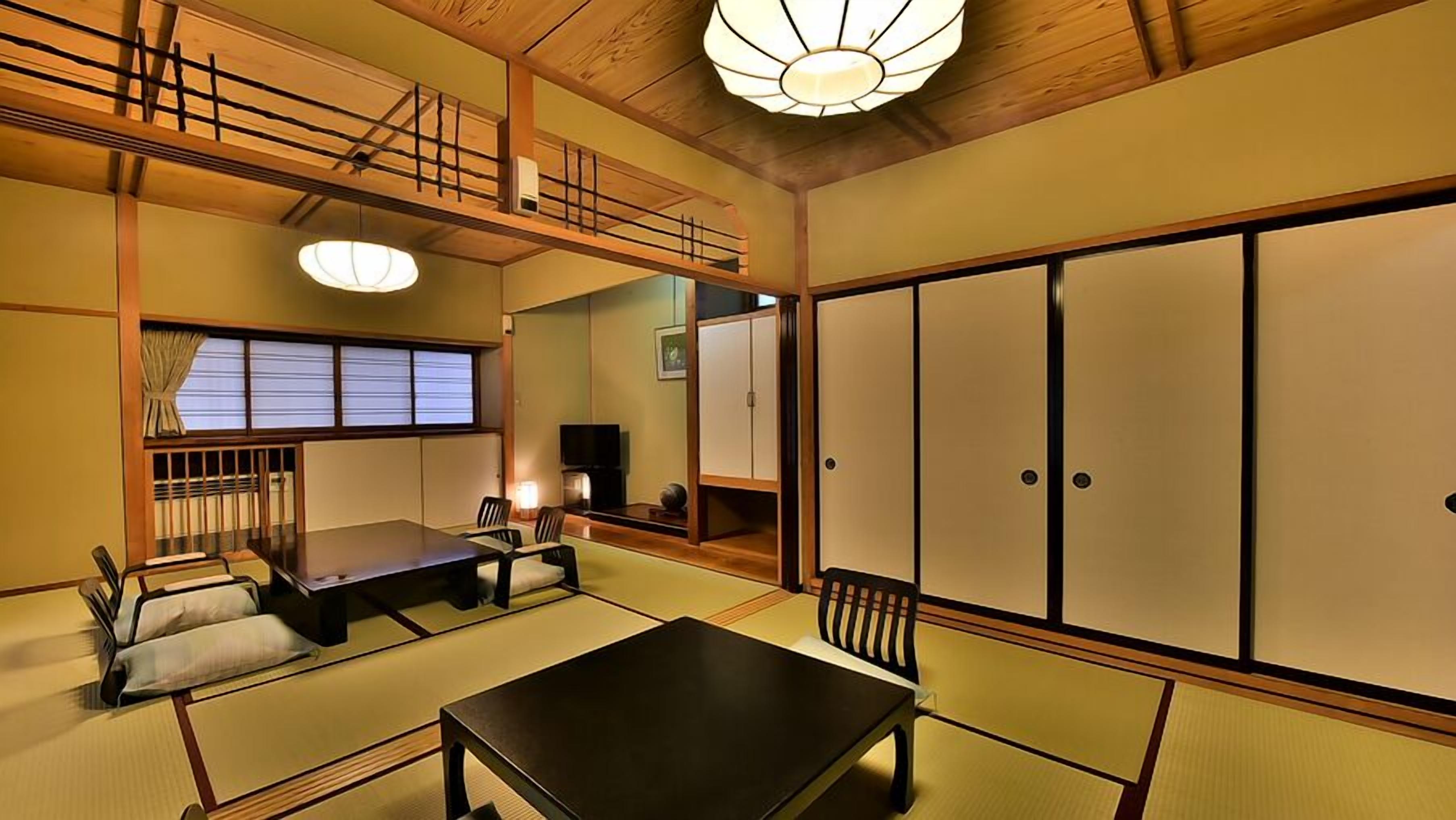 A traditional Japanese room with tatami flooring, a low table, a sofa, sliding doors, and a ceiling light fixture.