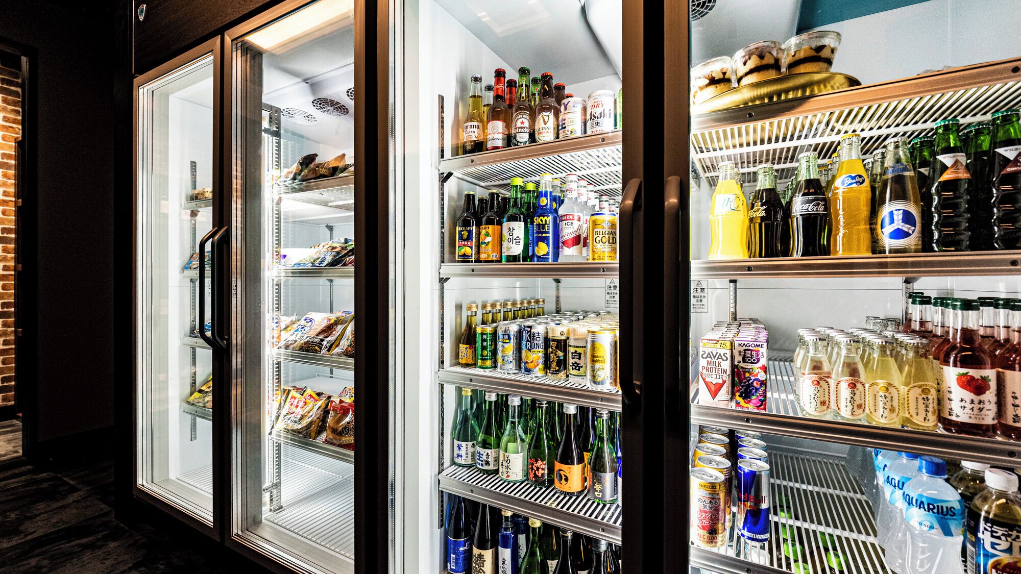 Three refrigerated display cases with various beverages and snacks.