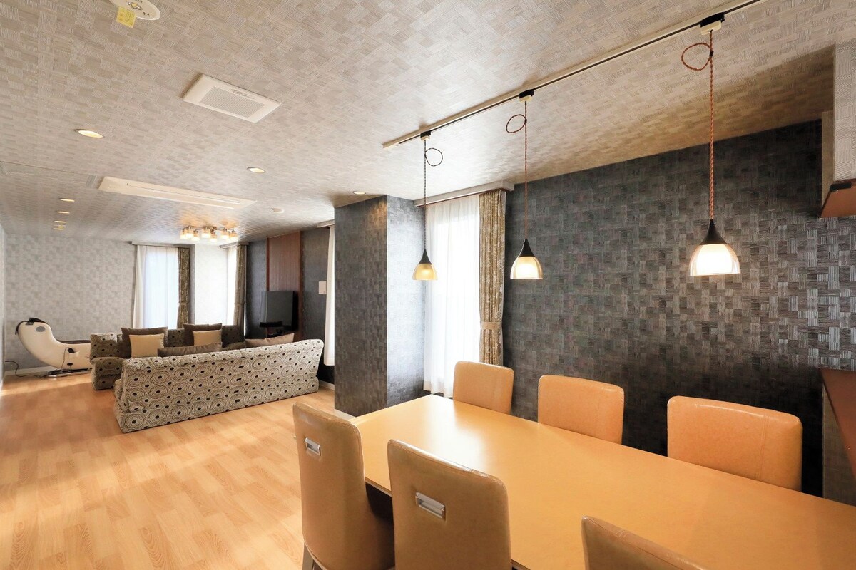 A modern interior with a dining area, a sofa, and a television.
