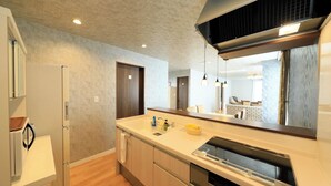 A modern kitchen with a built-in dishwasher, wooden cabinets, and a large mirror above the counter. - Point Vacation Gero (Gero)