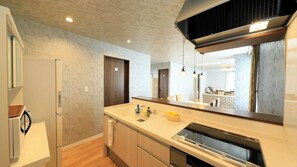 A modern kitchen with a built-in dishwasher, wooden cabinets, and a large mirror above the counter. - Point Vacation Gero (Gero)
