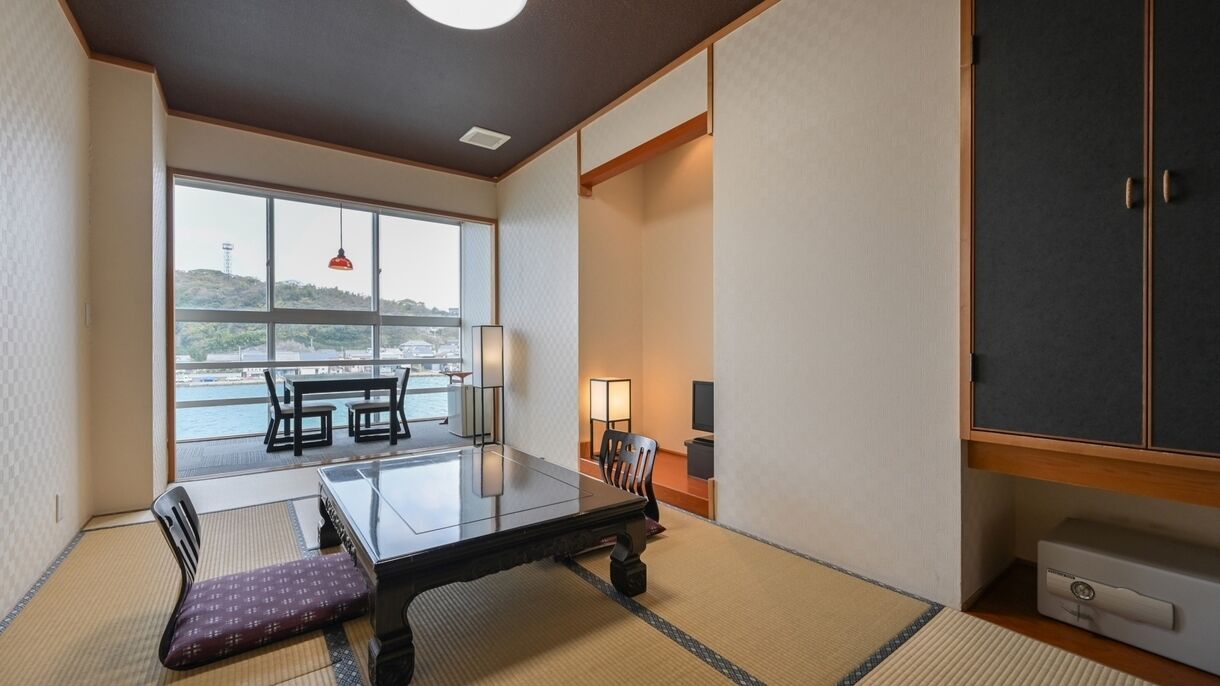 Ein traditioneller japanischer Raum mit Tatami-Böden, einem niedrigen Tisch und Blick auf das Meer.