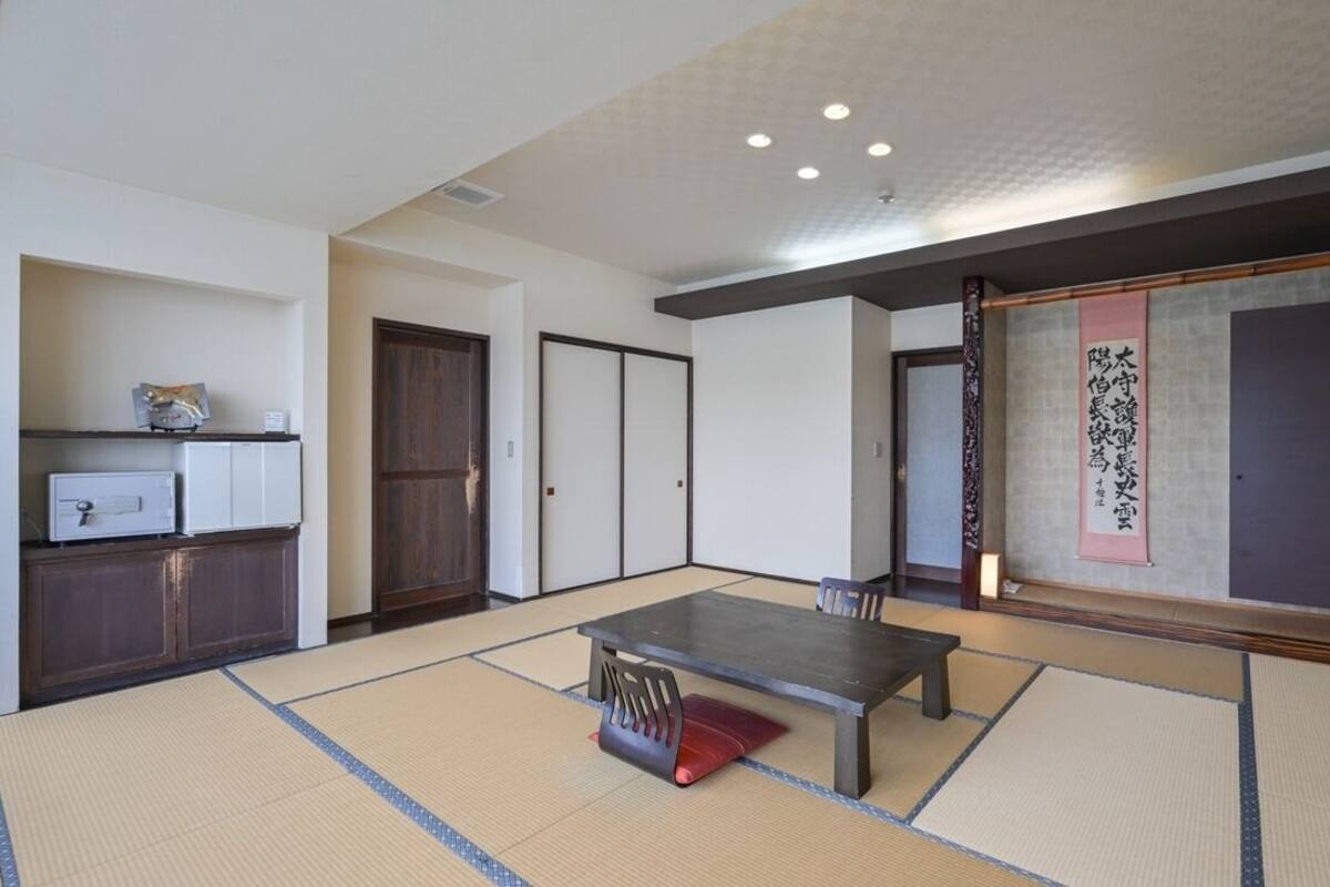A traditional Japanese room with tatami flooring, a low table, and sliding doors.
