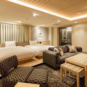 A hotel room with two beds, a sofa, a table, and a patterned rug. - Terrace Hotel f Shinosaka (Osaka)