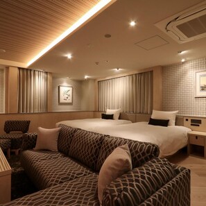 A hotel room with a large bed, a sofa, and a nightstand. - Terrace Hotel f Shinosaka (Osaka)