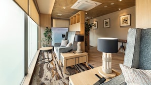 A modern interior with a sofa, a table, a lamp, and a chair.
