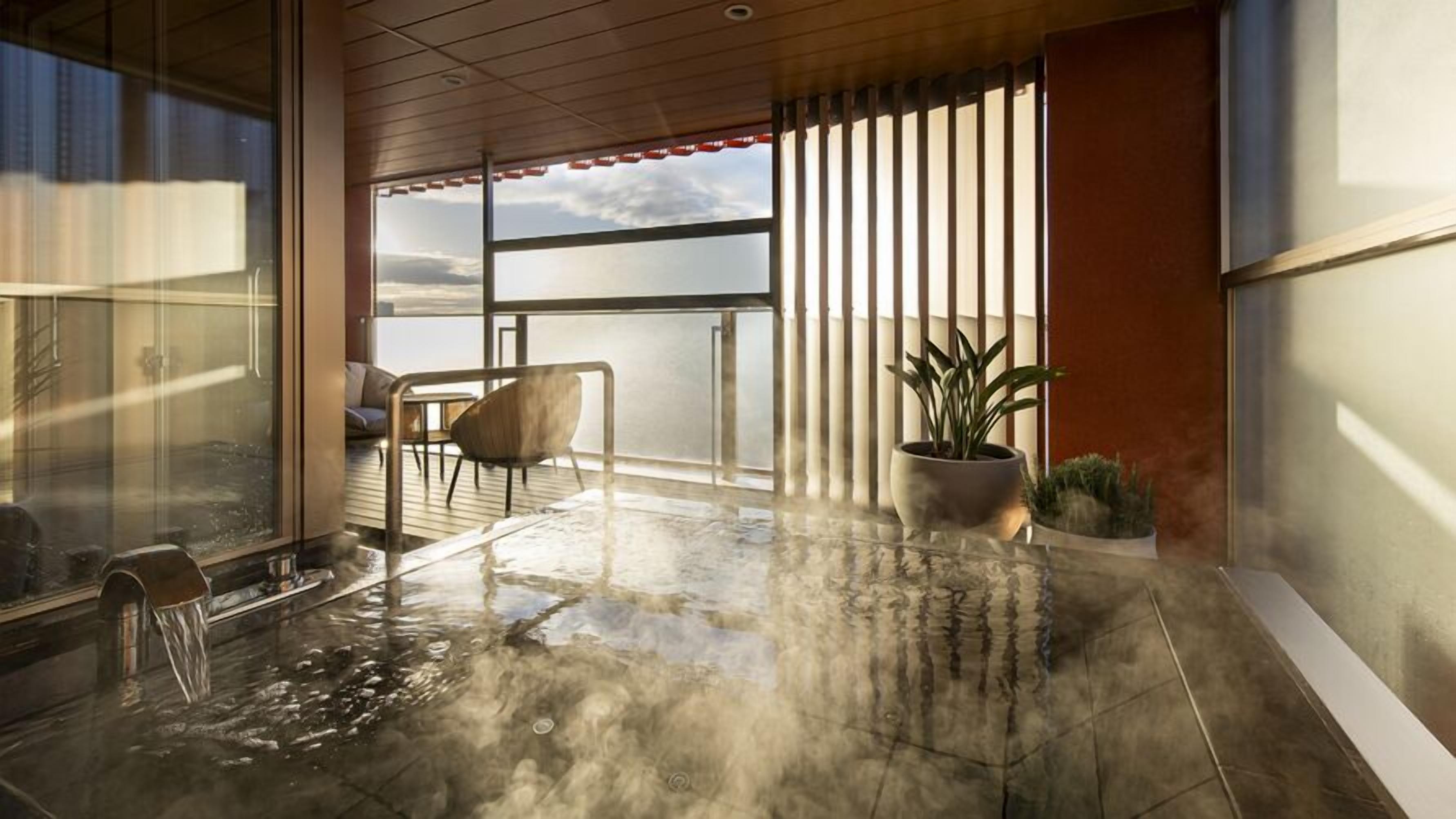 A modern balcony with a glass door, a seating area with a chair, a potted plant, and a view of the sky.
