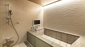 A modern bathroom with a shower, a vanity with a sink, and a textured wall. - Terrace Hotel f (Osaka)