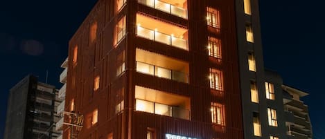 A multi-story hotel with a prominent 'Terrace Hotel' sign, featuring balconies and a modern architectural design.