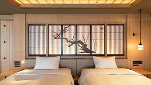 A hotel room with two beds, a wooden headboard, a decorative screen with branches, and a bedside table with a lamp. - Terrace Hotel f (Osaka)
