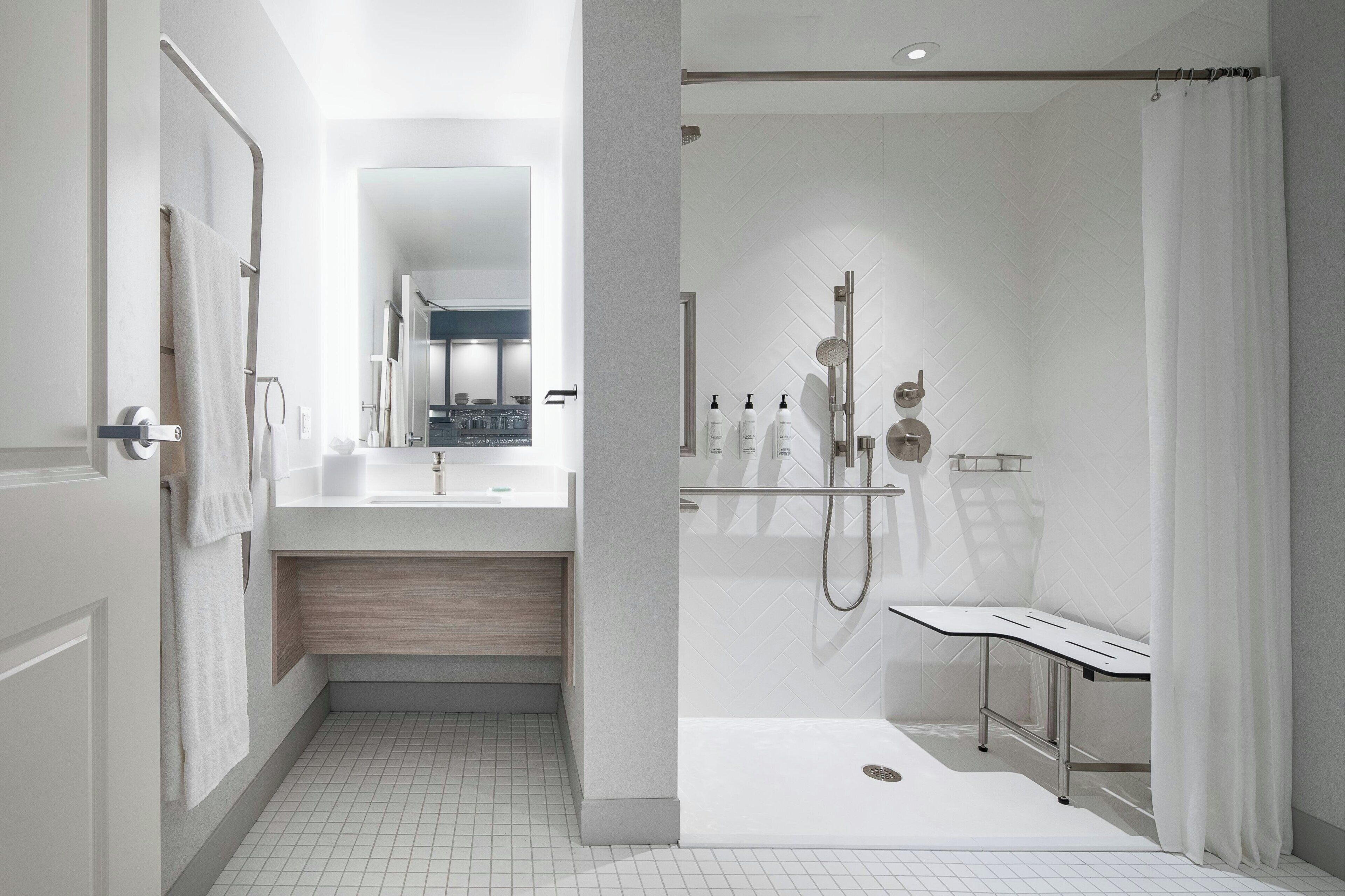 A modern bathroom with a walk-in shower, a vanity with a mirror, and a toilet.