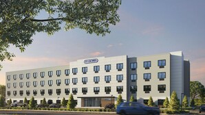 A multi-story hotel with a modern design, featuring a prominent 'STUDIOS' sign, multiple windows, and a parking area with cars. - StudioRes by Marriott Mesa (Mesa)