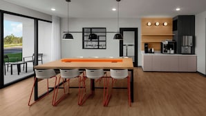 A modern kitchen with a wooden table, four chairs, and a coffee machine. - StudioRes by Marriott Mesa (Mesa)