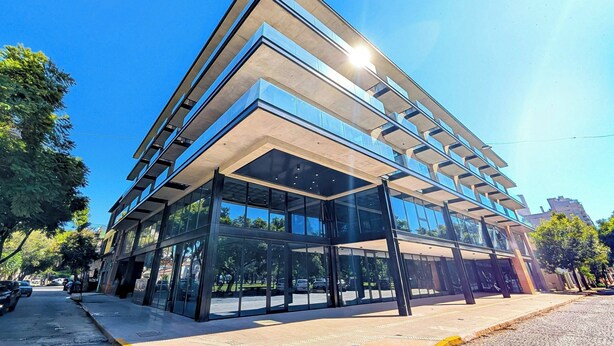 A modern building with a glass facade, multiple floors, and a flat roof. - Brickton, Rosario, Apartments By Marriott Bonvoy (Rosario)