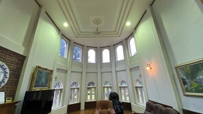 A spacious room with high ceilings, multiple arched windows, a fireplace, and a massage chair. - Tabino Teitaku Realiser Zao (Zao)