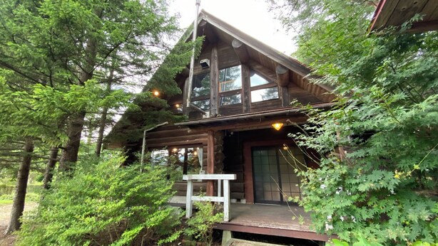 A log cabin with a porch, surrounded by dense forest. - Tabino Teitaku Realiser Zao (Zao)