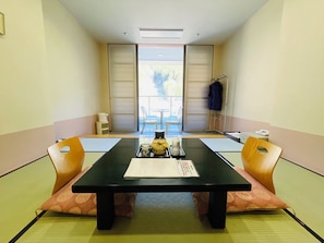 A traditional Japanese-style room with tatami flooring, a low table with a tray of tea utensils, and sliding doors leading to an outdoor area. - Hida-kanayama Nukumori-no-sato Onsen (Gero)