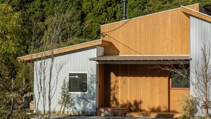 Ein modernes Haus mit Holzfassade, einer Garage und einer Auffahrt.