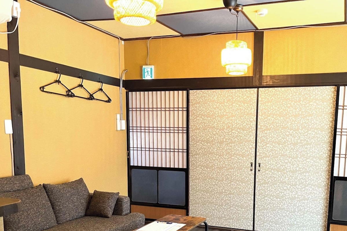 Ein Zimmer mit einer Couch, einem kleinen Tisch und einer Schiebetür mit einem Zierdekor.