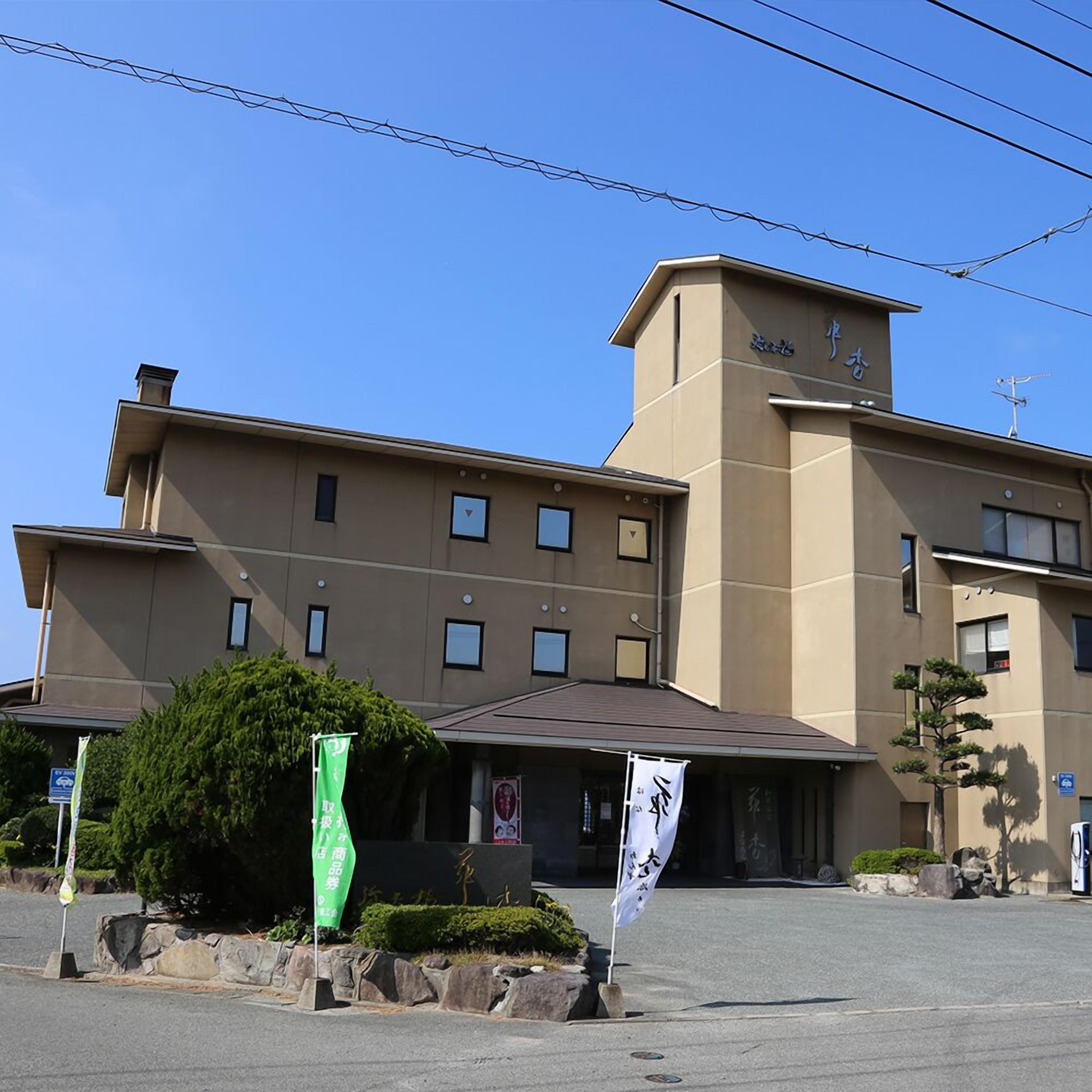 Un hôtel à plusieurs étages, doté d’un toit plat, d’une grande entrée et d’une enseigne.