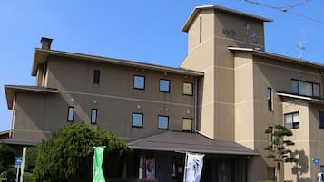 Un hôtel à plusieurs étages, doté d’un toit plat, d’une grande entrée et d’une enseigne.