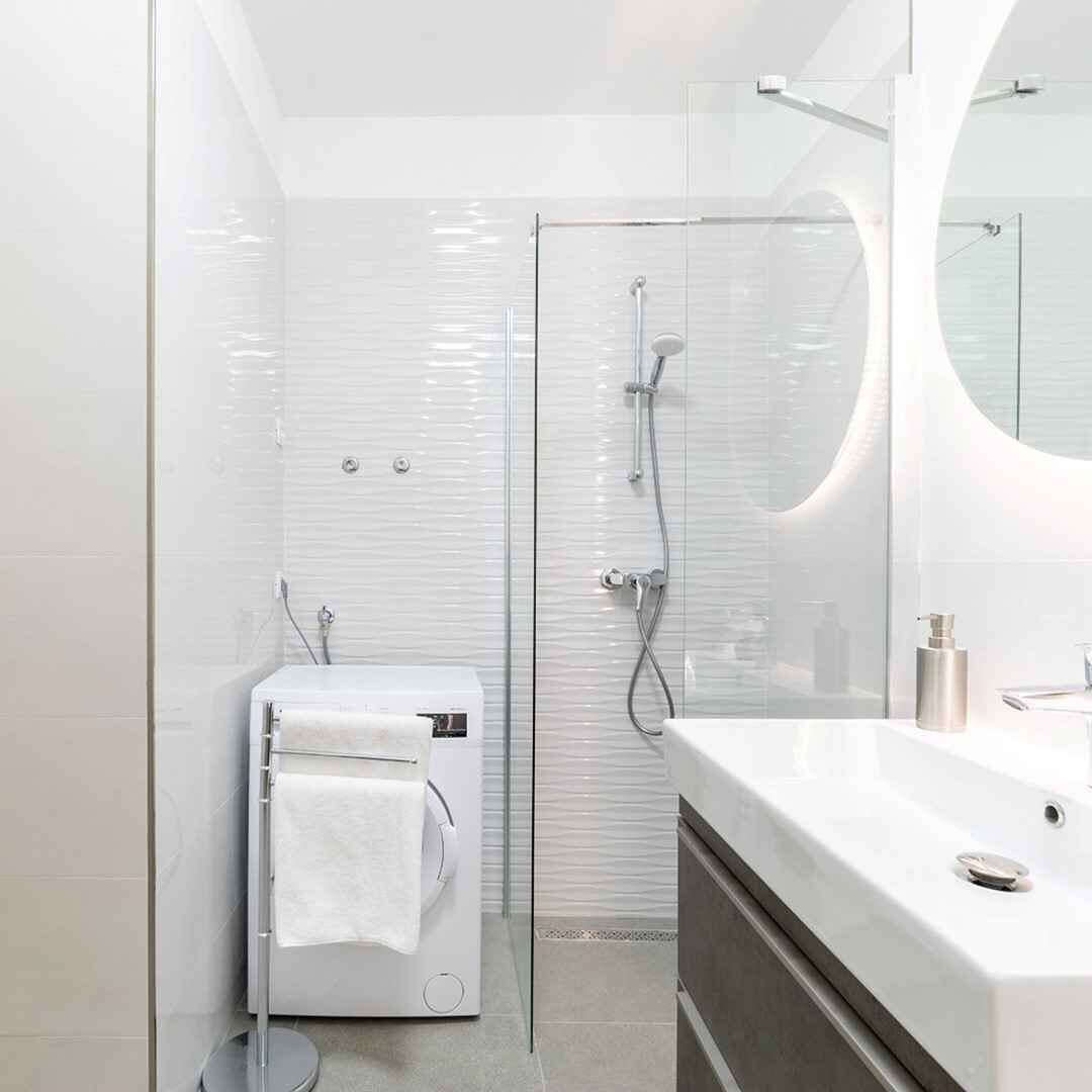 A modern bathroom with a glass shower enclosure, a built-in toilet, and a vanity with a mirror.