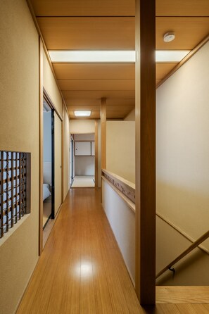 A hallway with wooden flooring, a ceiling with recessed lighting, and a wooden column. - Anjin Gosho Ebisugawa (Kyoto)