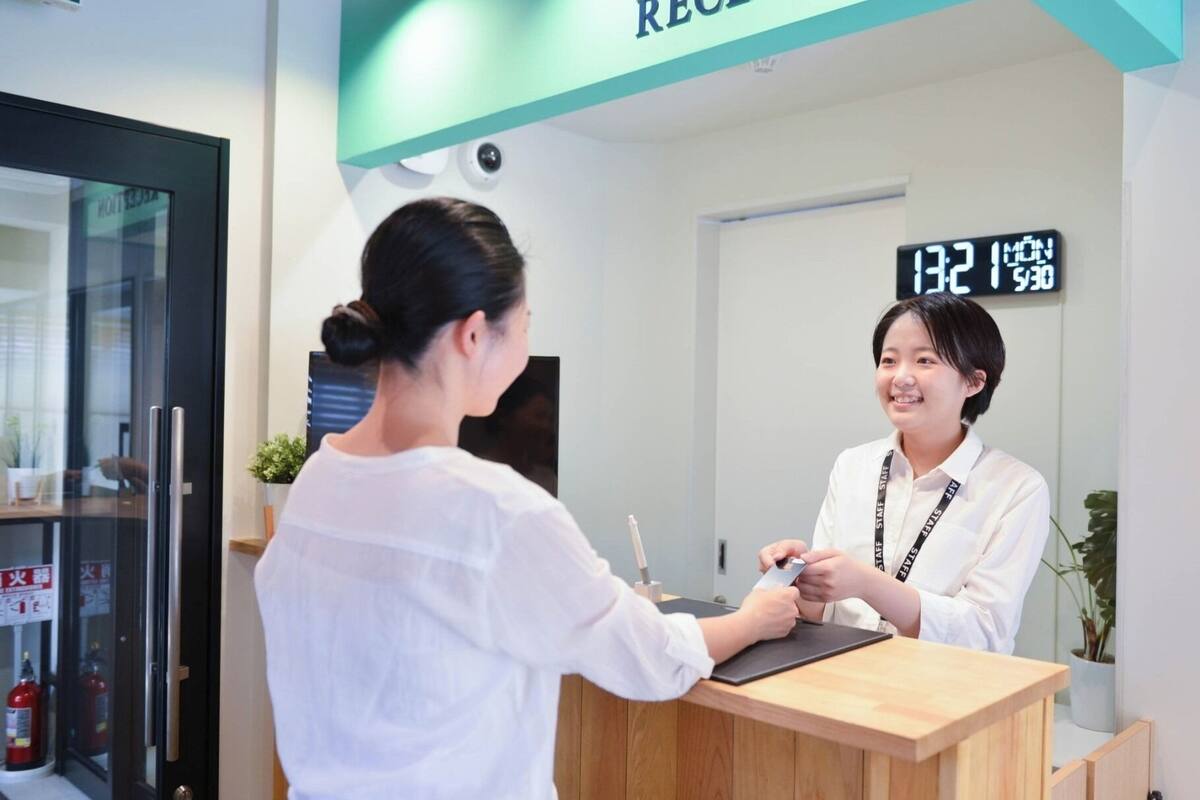 A reception area with a digital clock displaying the time, a reception desk, and a sign above indicating the reception.