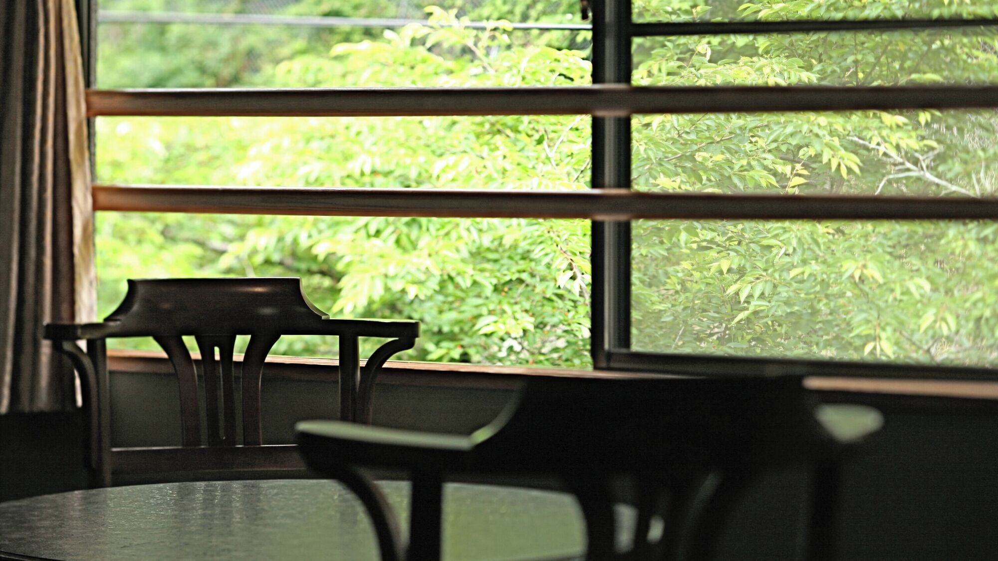 A room with a window, a chair, and a table.