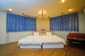A bedroom with a large bed, a sofa, and a small table. - Gero Springs Hotel (Gero)
