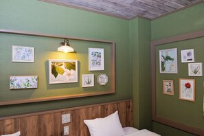 A room with a green wall, wooden paneling, and multiple framed botanical illustrations. - Gero Springs Hotel (Gero)