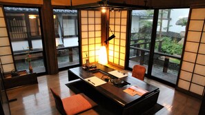 Une pièce de style japonais traditionnel, avec un sol recouvert de tatamis, une table basse et des portes coulissantes.