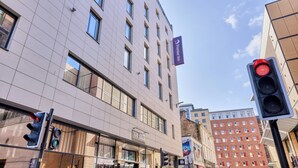 A modern building with a flat facade, multiple windows, and a pedestrian crossing signal. - Premier Inn Glasgow City Centre Hotel (Glasgow)