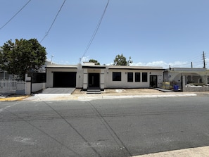 A building with a garage, a gated entrance, and a paved driveway.