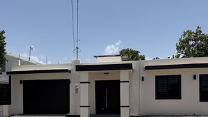 Een gebouw met twee verdiepingen, een garage op de begane grond en een voordeur met treden.