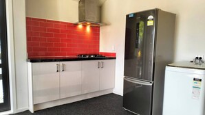 A kitchen with a red-tiled backsplash, stainless steel appliances, and white cabinetry. - Room-quite and Cozy Double Bedroom (Christchurch)