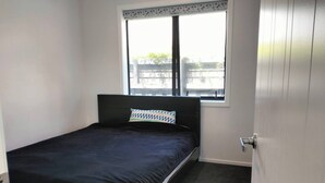 A small, single-bed room with a window, a door, and a carpeted floor. - Room-quite and Cozy Double Bedroom (Christchurch)