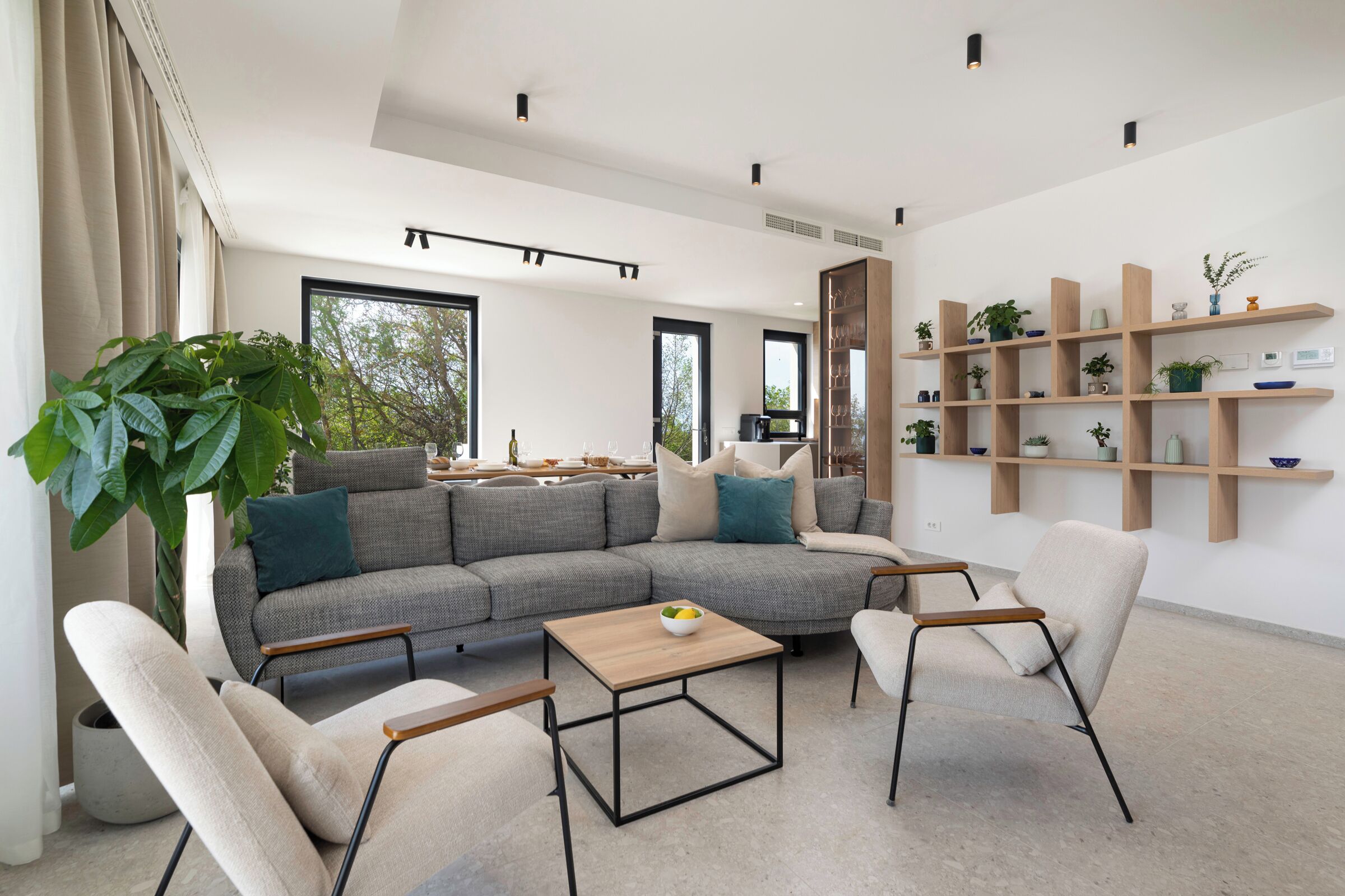 Una sala de estar moderna con un sofá modular, una mesa de centro y una estantería.
