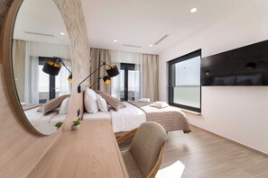 Une chambre d’hôtel moderne avec un grand lit, un bureau, une chaise, un miroir et une grande fenêtre.