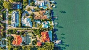 Eine Luftaufnahme eines Küstenwohngebiets mit Häusern, einem Hafen und freiem Blick auf das Wasser.