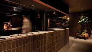 A modern kitchen with a brick backsplash, stainless steel appliances, and a counter with plates. - Fufu Karuizawa (Karuizawa)
