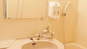 Ein Badezimmer mit Waschbecken, Spiegel, Seifenspender und Dusche.