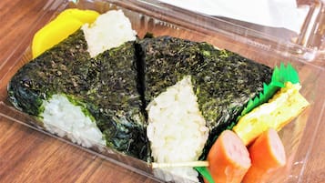 A packaged meal with rice, seaweed, and vegetables.