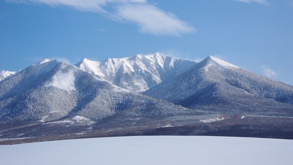 A snow-covered mountain range with clear skies. - Guesthouse Akane-yado (Nakafurano)