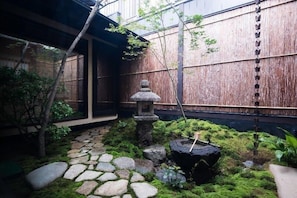 En traditionel japansk have med en stenhlygt, mos og et træhegn.