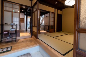 Et traditionelt japansk rum med tatami gulv, skydedøre og en hylde med toiletartikler.