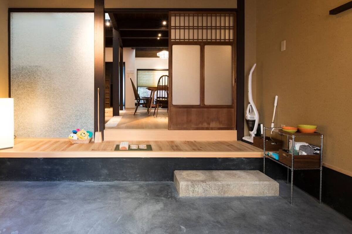Ein traditionelles japanisches Interieur mit Tatami-Böden, einer Schiebetür und einem Empfangstresen mit Lampe.