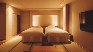 Una habitación con dos camas, televisión y puertas correderas.